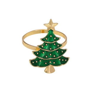 Golden metal napkin ring featuring a green enamel Christmas tree on a white backdrop