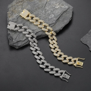 20mm gold and silver iced-out Cuban link bracelets set on stone background