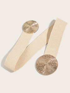 Detail of beige woven elastic belt with golden radial sunburst metal buckle for dresses
