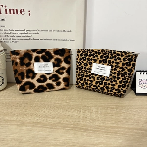 Vintage leopard print corduroy makeup bag set for portable lipstick storage on wood desk