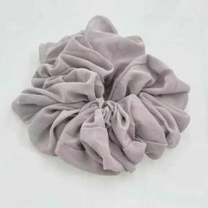 Detailed close-up of soft lavender chiffon scrunchie with elegant pleated fabric texture