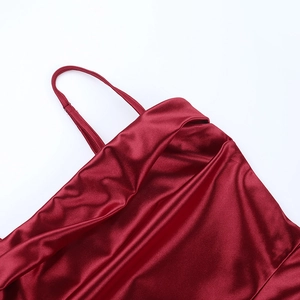 Detailed view of dark red satin fabric and thin straps on a mini cocktail dress