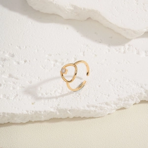 Detail of a gold adjustable ring featuring a round geometric centerpiece with clear zircon