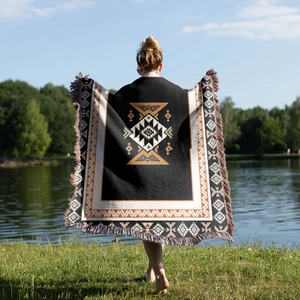 Detail of bohemian outdoor blanket with geometric patterns and long handmade tassels