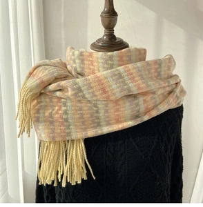 Close-up of soft rainbow plaid scarf featuring thick tassels and pastel color blocking