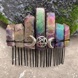 Detailed view of raw rainbow crystals and silver moon pentagram on a black hair comb