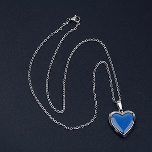 Stainless steel heart locket necklace with temperature color change pendant on black background