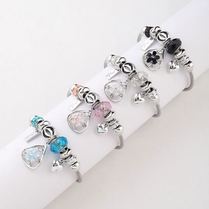 Detail of colorful charm bracelets with faceted beads and heart pendants on white display
