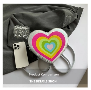 Macro shot of silver heart-shaped crossbody bag with vibrant colorful layered heart print
