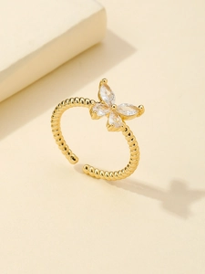 Macro view of gold bow ring with marquise cut zircon and braided band design