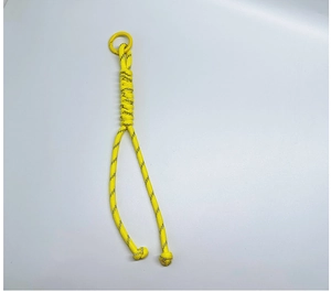Macro detail of hand-woven yellow paracord lanyard with durable metal keyring