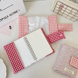 Detailed view of floral and plaid fabric book covers with pink button closures