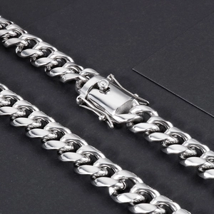 Macro view of silver stainless steel Cuban link chain with detailed lobster box clasp