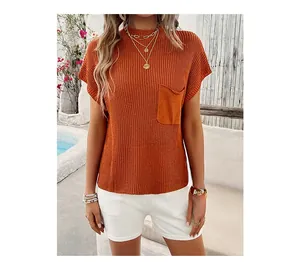 Detail of orange ribbed knit short sleeve top with a square chest pocket and soft texture