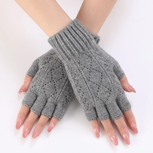 Detail of grey knitted fingerless arm warmers with diamond hollow pattern and ribbed cuffs