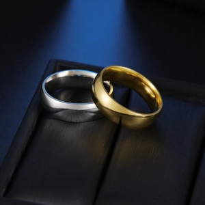 Macro shot of gold and silver 6mm stainless steel band rings on black jewelry box