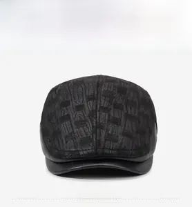 Close-up of a vintage black beret hat with grey jacquard fabric and a sleek leather brim