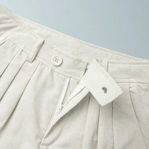 Detail der Leinenhose-Taille mit Knopfverschluss und Gürtelschlaufen in hellem Beige