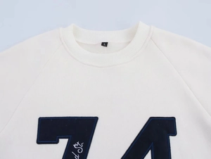 Detail view of white crew neck sweatshirt collar with knitted texture and letter printing