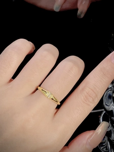 Close-up of a minimalist gold ring set with three yellow stones on a model's hand