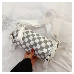 Detailed view of the gray checkered cylinder bag with wide strap and pleated texture