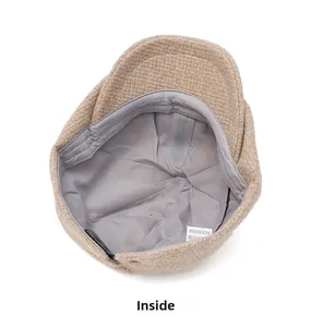 Detail view of the beige tweed flat cap interior with gray lining and washing label