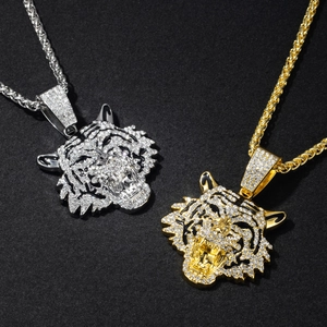 Close-up of gold and silver tiger head pendants with sparkling crystal inlay for men