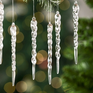 Clear spiral icicle Christmas tree ornaments set with glowing warm bokeh background