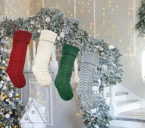 Set of four knitted Christmas stockings in red green beige and grey on stairs
