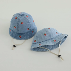 Detail of light blue denim baby bucket hat with strawberry embroidery and chin strap