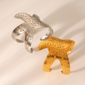 Detail of gold and silver starfish bangles with textured finish and embossed dots