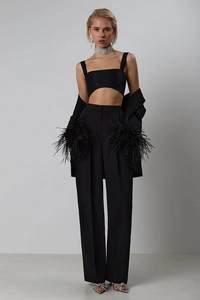 Close-up of elegant black suit set featuring luxury feather trim on the blazer cuffs