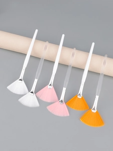 Detailed view of fan-shaped facial masks brushes with white and transparent handles