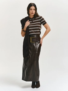 Detail of slim fit striped polo shirt paired with high-shine leather skirt and wide belt