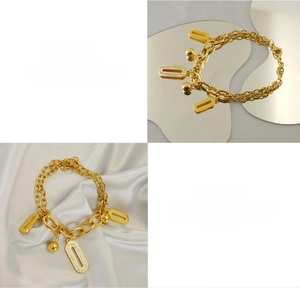 Détail d'un bracelet double couche en acier doré 18K avec pendentif ovale en zircon