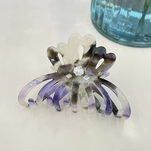 Elegant marble acetate flower hair claw clip with rhinestones and gold lettering detail