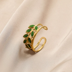 Detail of gold leaf ring with green enamel finish on a soft champagne silk background