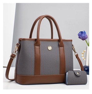 Detailed view of grey canvas and brown leather tote bag with matching mini pouch and sun charm