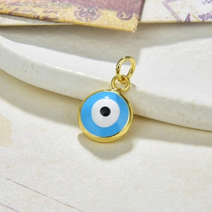 Macro shot of blue enamel evil eye pendant with gold plated rim and polished bale