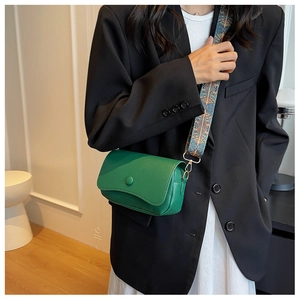 Detail of green lychee leather bag with colorful ethnic style wide shoulder strap
