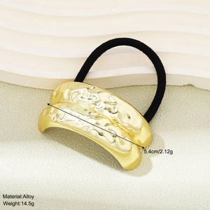 Detailed view of minimalist gold alloy hair tie showing unique hammered metal texture