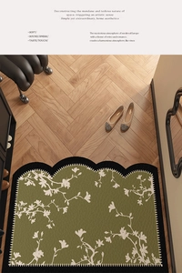 Detail of semi-circular green PVC leather floor mat with floral patterns on wood floor