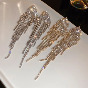 Detailed close-up of sparkling long tassel drop earrings in gold and silver finish