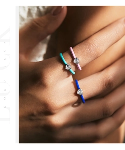 Close-up of three colorful enamel heart rings set with sparkling heart zircons on a hand