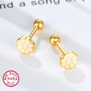 Macro detail of 925 sterling silver daisy stud earrings with white enamel and gold finish