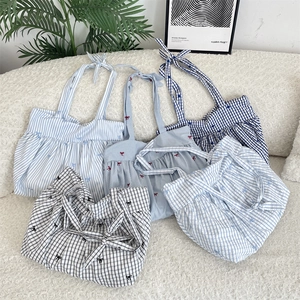 Detail view showing a collection of pleated canvas tote bags in various plaid patterns
