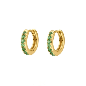 Macro shot of gold hoop earrings featuring meticulous channel-set round green zircons