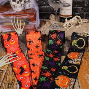 Halloween ribbons with spider, bat, and pumpkin prints on a wooden table setup