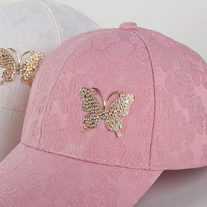 Close-up of floral lace baseball cap with sparkling rhinestone butterfly accessory