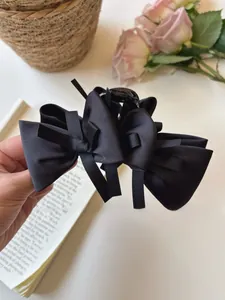 Detail of elegant black multi-layered bow hair claw clip in matte satin finish